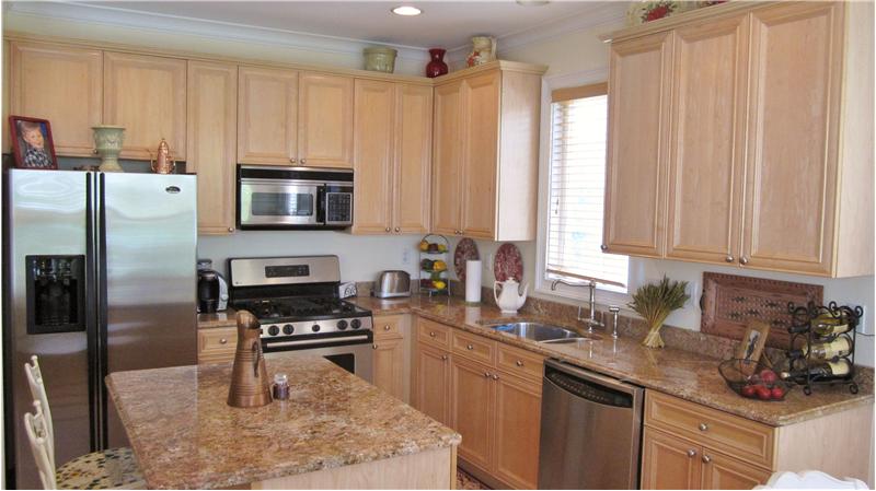 Kitchen with island, granite countertops and stainless steel appliances